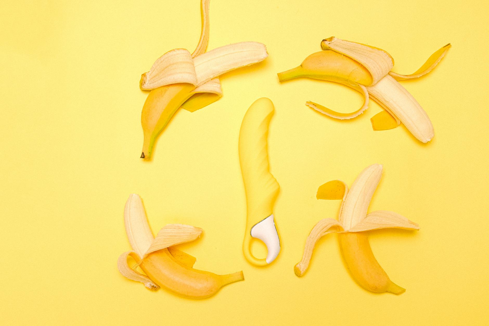 Vibrador de limão amarelo em composição artística com limões frescos em fundo amarelo