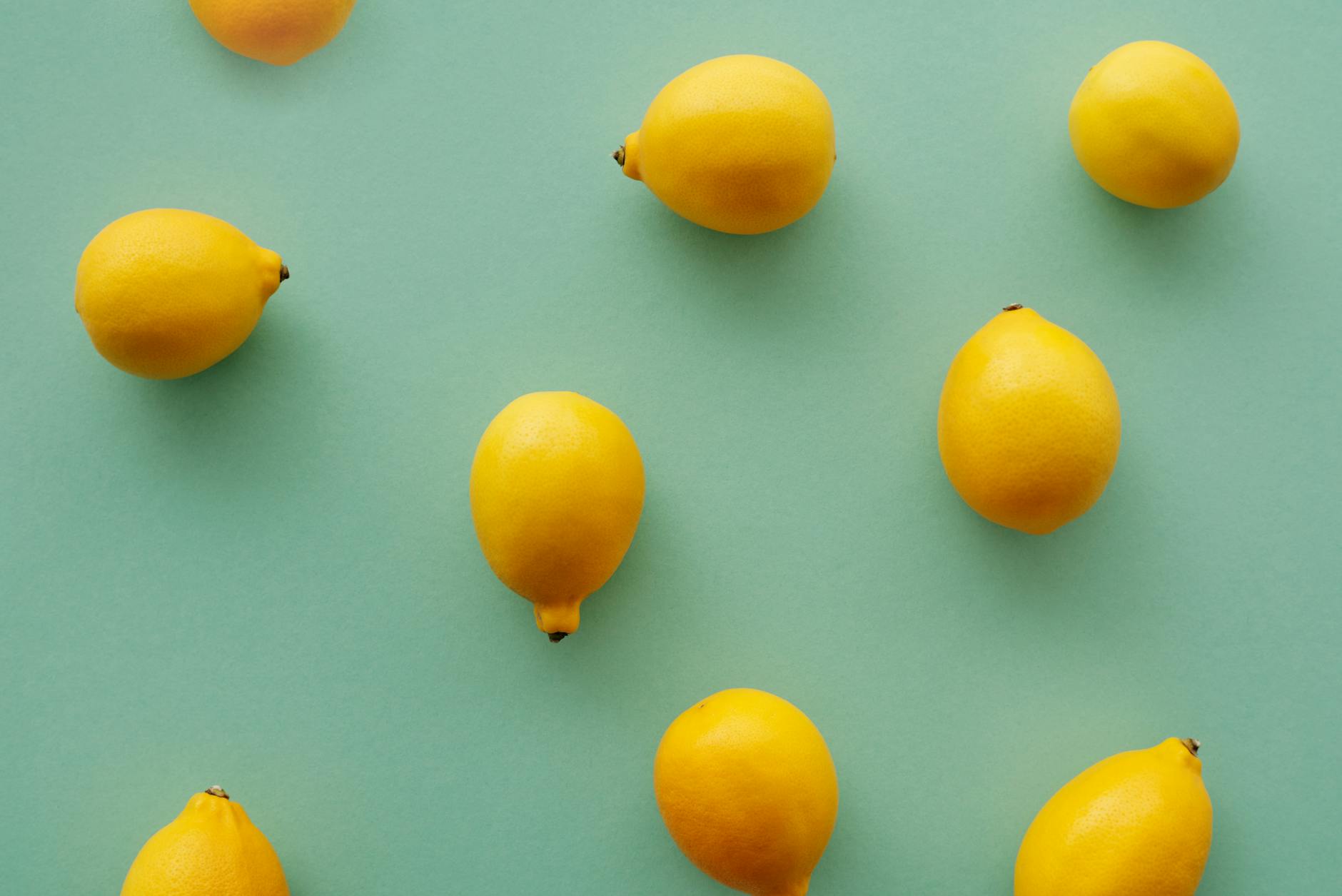 Vibradores coloridos de limão dispostos em fundo amarelo brilhante, mostrando várias formas e designs