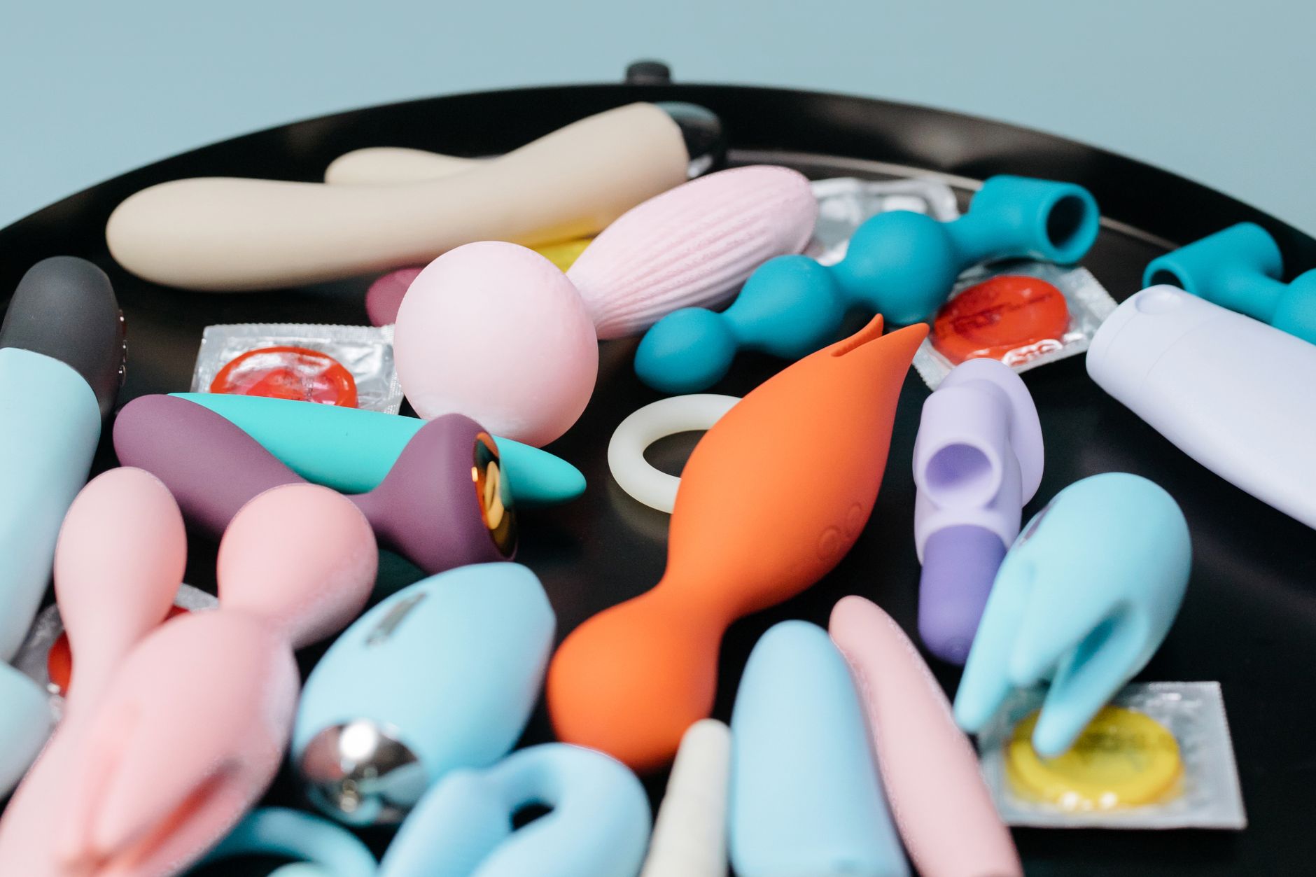 Vibrador de silicone azul seguro na mão contra fundo roxo, promovendo prazer e amor próprio