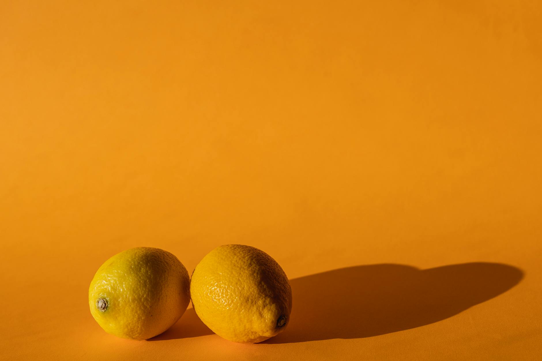 Limões vibrantes sobre fundo amarelo claro, simbolizando retomada de sensação clitoriana
